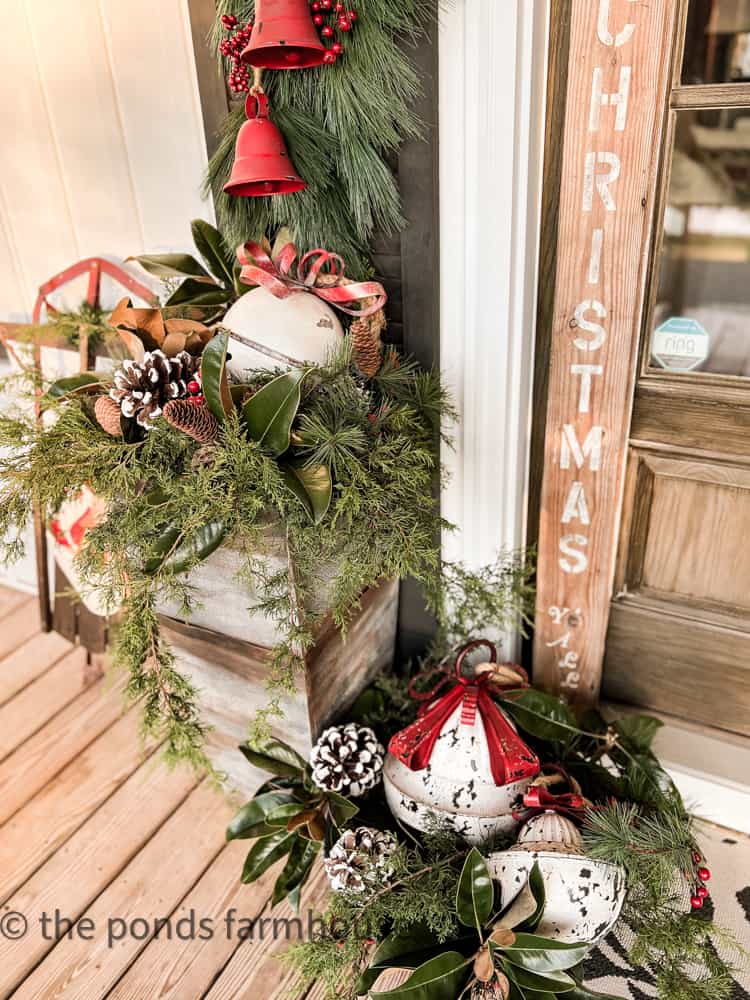 Foraged Greenery and Bells Decorate the front porch for Christmas