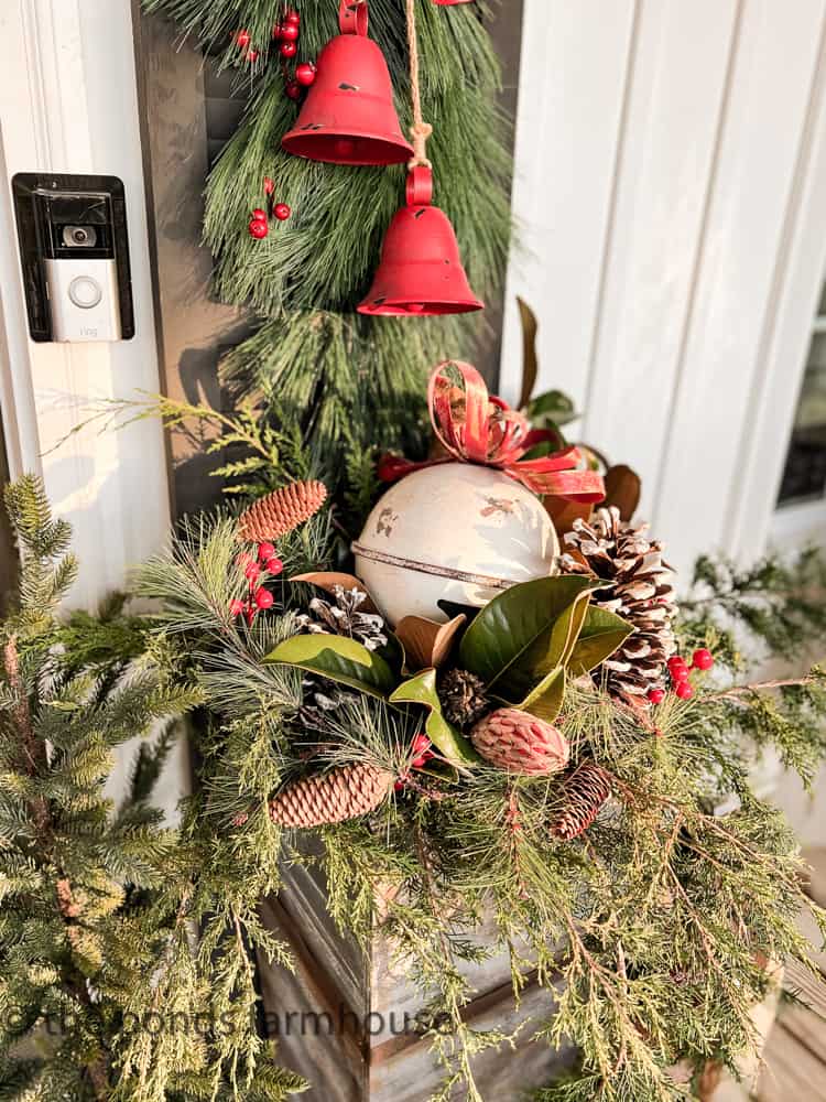 DIY planter filled with real cedar, magnolias, pinecones and bells