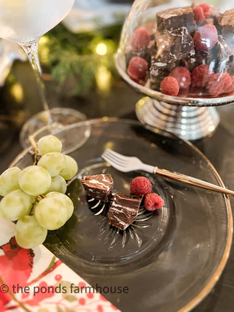 Dark Chocolate Raspberry Fudge on a christmas plate with fruit.