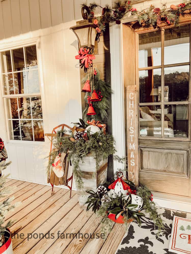 Greenery and bells decorate the front porch for Christmas