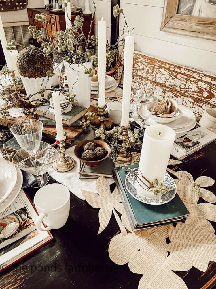 Moss stems and moss balls added vintage milk glass and antique brass candlesticks with tapered candles for a bookclub brunch table setting.