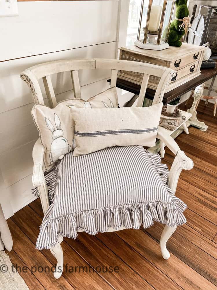 The After image of deconstructed chair with new seat cushion and pillows.  Painted old white by Annie Sloan.