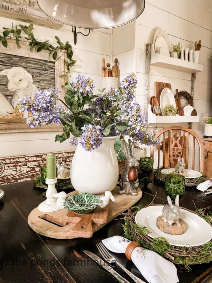 Ironstone Vase with lilac and pewter bunnies.  Thrifted Breadboards make up Easter Table Centerpiece.