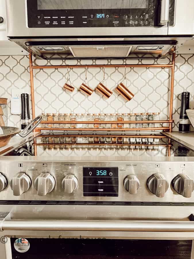 Built In DIY Copper Pipe Spice Rack with Vintage Spice Bottles with copper tops and old copper measuring cups