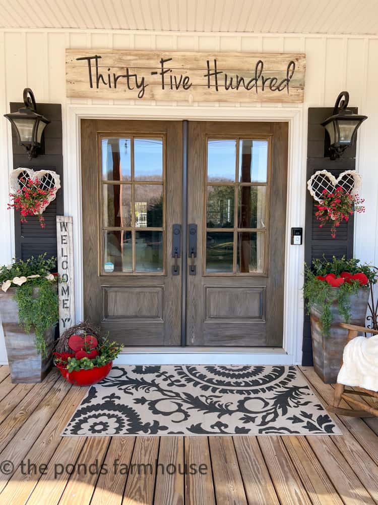 DIY Valentine's hearts on front door shutters of farmhouse.