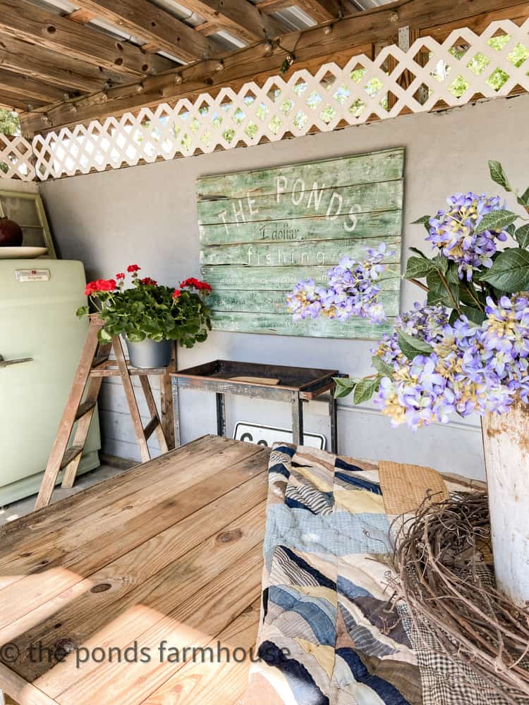 Inside the outdoor area  is a reproduction sign and vintage refrigerator.