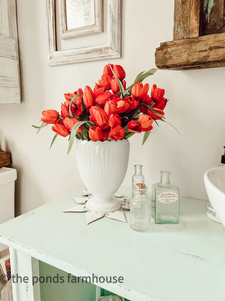 Milk Glass Vase filled with red tulips and old green bottles for Valentine's Decor Ideas