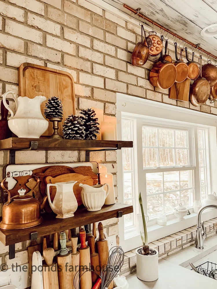 Cozy Winter Kitchen with open shelving and copper pots on a brick back splash for Farmhouse Winter Decor