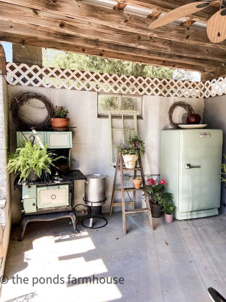 The DIY outdoor kitchen has a vintage wood cook stove and a vintage hot point refrigerator.  