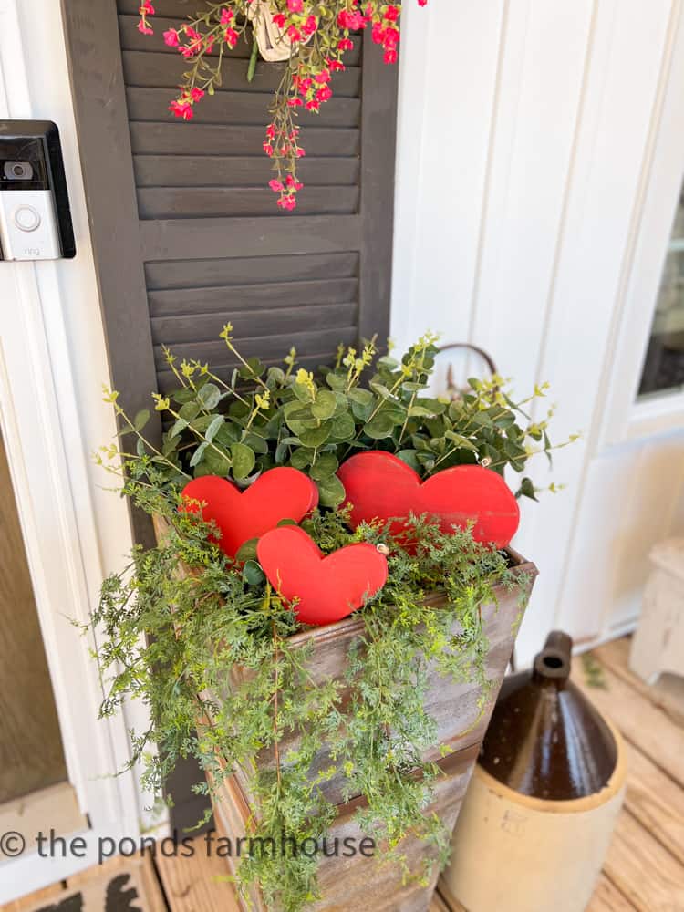 DIY faux galvanized planters filled with DIY wooden heart trio and faux greenery