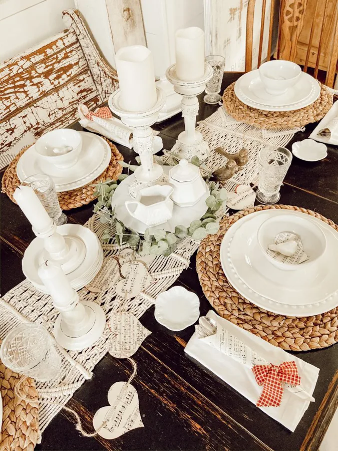 Neutral Valentine's Decor with white dishes, thrifted white candlesticks, DIY paper garlands and cutlery cones. 