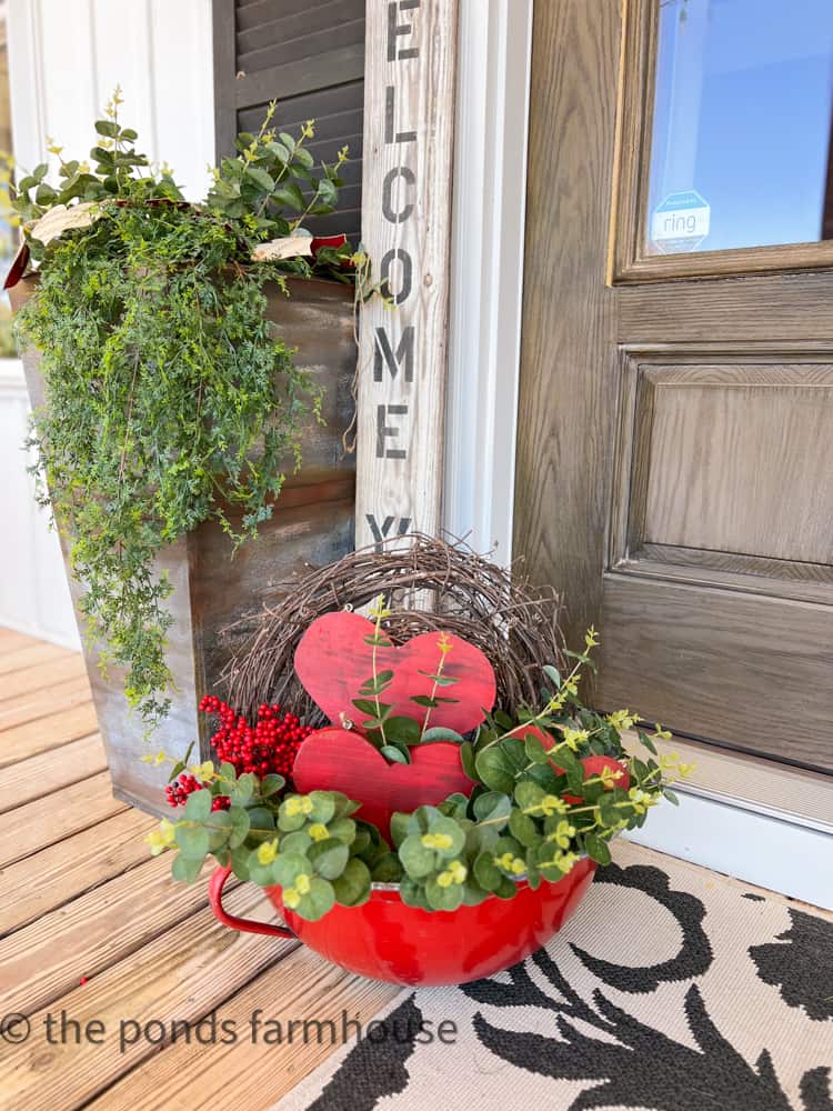 Antique enamelware bowl filled with faux greenery and wooden hearts for Valentines Porch Decorations