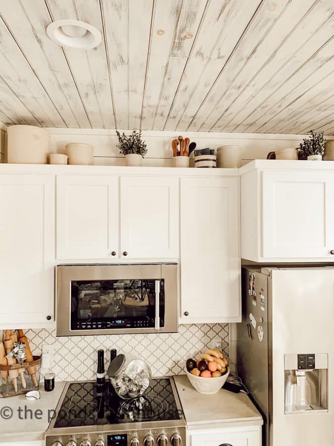 Add vintage crock collection above kitchen cabinets