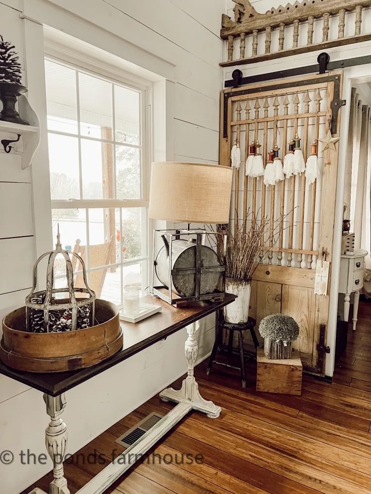Farmhouse Winter Decor Entryway with antique barn door and repurposed gas can lamp.  Forced Stems
