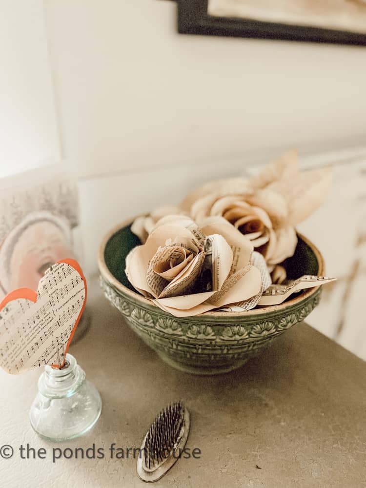 vintage bowl filled with vintage book page paper flowers.  Farmhouse Style decor Flower with paper folding