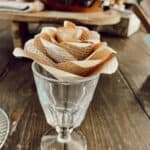 old book page paper rose in a clear water goblet