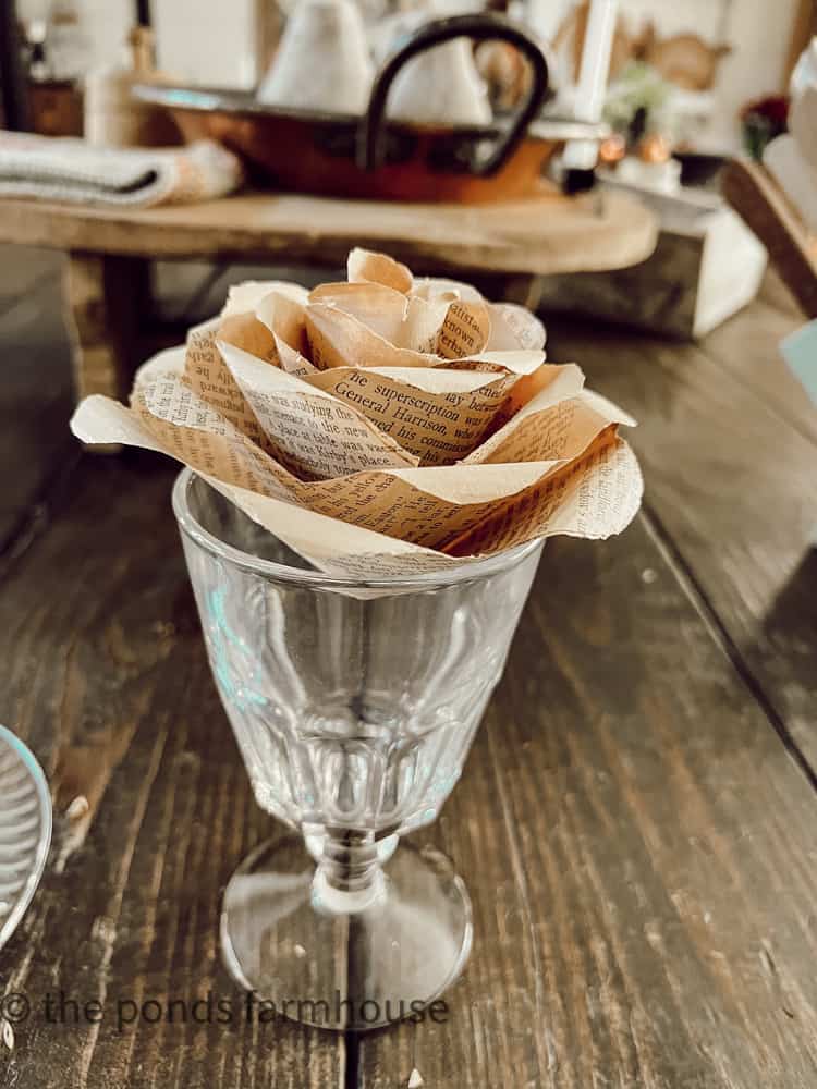 Use glass to hold paper rose steady while the glue dries