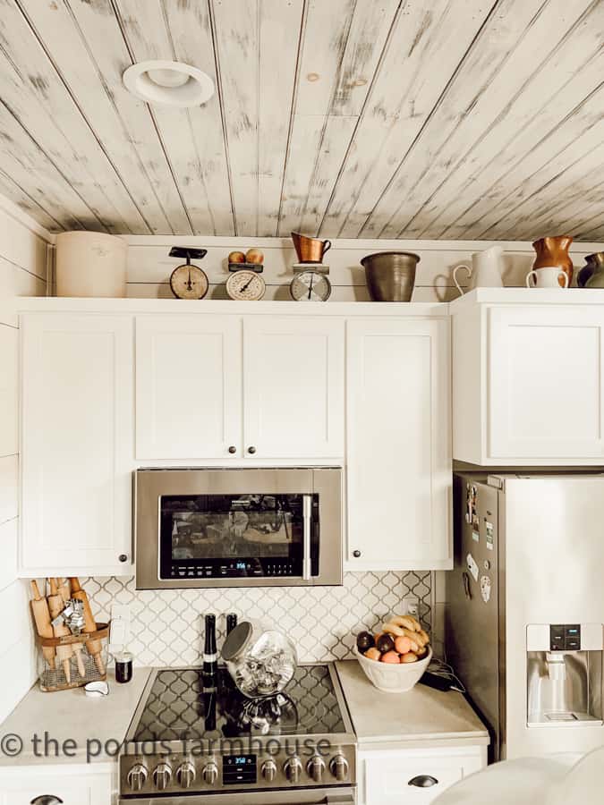 Decorating above kitchen cabinets with vintage and thrift store collections - shaker cabinets painted white and concrete countertops