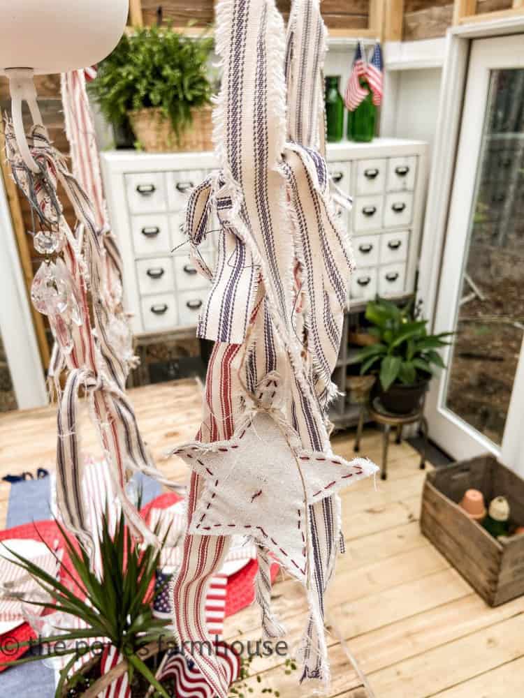 Ticking Strip streamers handing form DIY Chandelier in Greenhouse She Shed.