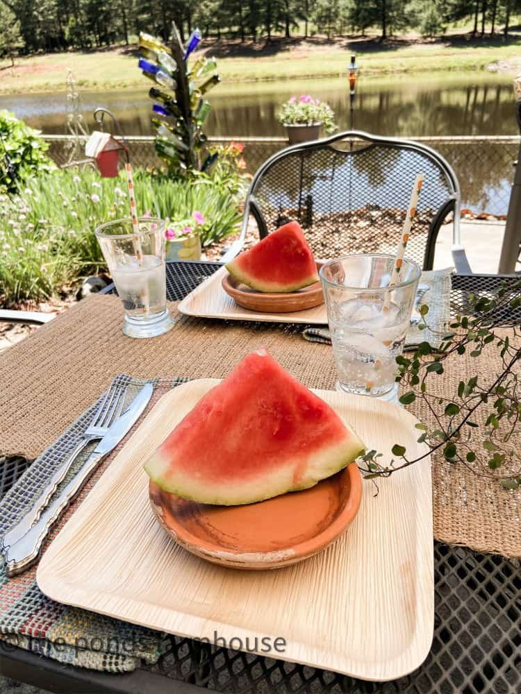 Watermelon served on clay saucers for a summertime outdoor party by the ponds at outdoor kitchen