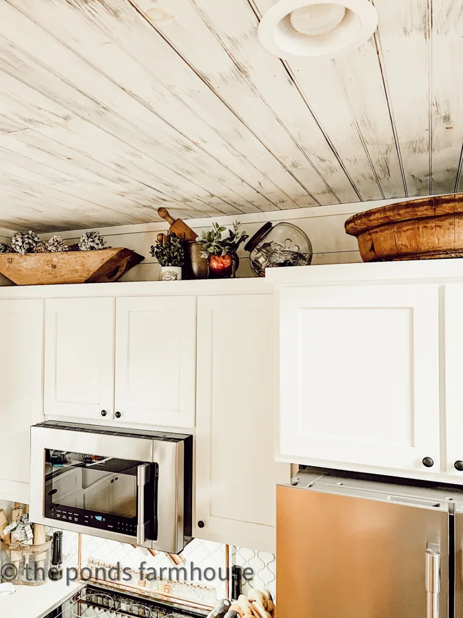 Add vintage to a modern farmhouse kitchen. Add collectibles to decorate above kitchen cabinets in modern farmhouse.