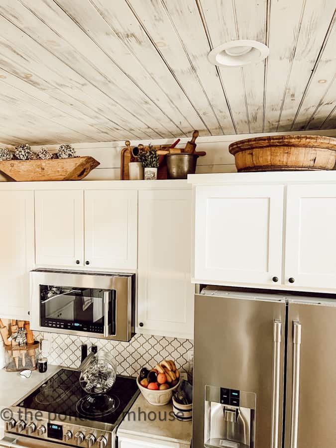 Vintage dough Bowl and large European wooden bowl above cabinets in modern farmhouse kitchen