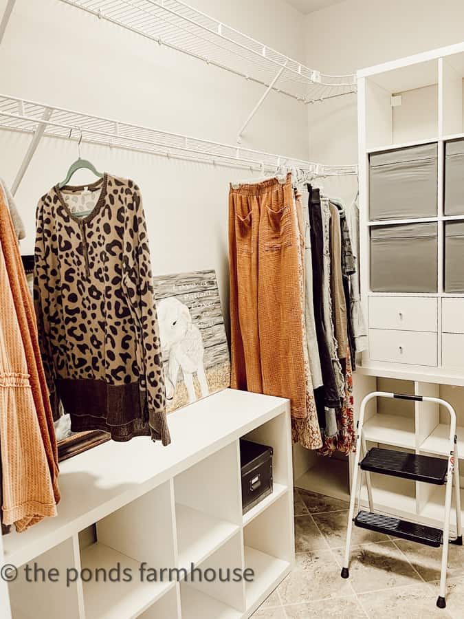 IKEA Kallax Units combined with existing wire racks to create storage space in walk-in closet. budget closet makeover ideas.