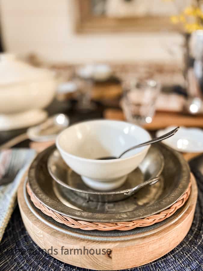 French Bowl with pewter spoon on vintage tins pans make up a rustic table setting for chili cook-off supper club.