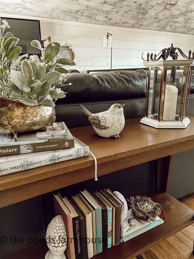 How To decorate a Sofa table for spring with birds and books. Include lanterns and vintage brass container.