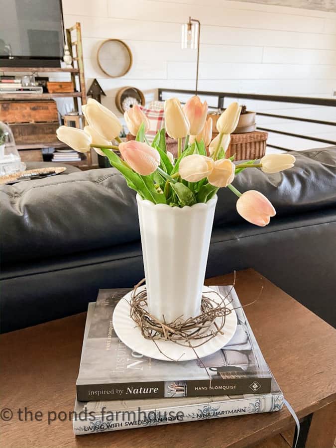 Milk Glass Vase filled with tulips on ironstone plate and decor books - Decorating Sofa Table Ideas for Spring