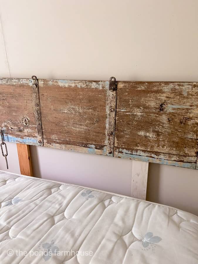 Paint the legs of the headboard to match the wall.  