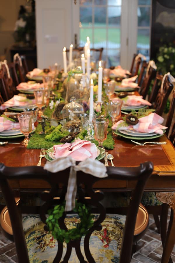 An elegant Easter Dinner Party Table is a great Easter Idea for entertaining.  Pink and white buffalo print napkins and a moss table runner.