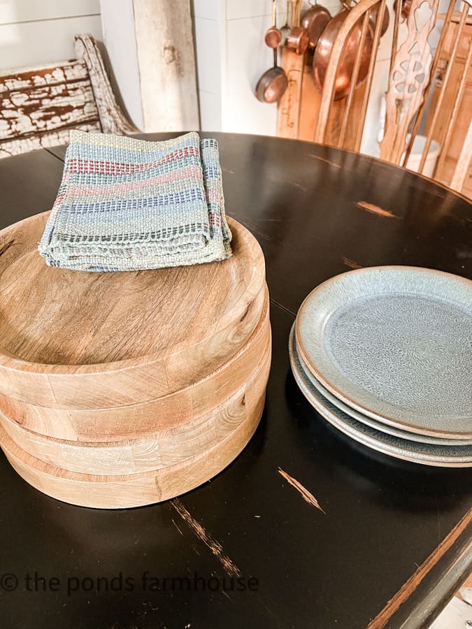 rustic table setting includes vintage pottery dishes from Seagrove Pottery, wooden chargers and woven napkins.