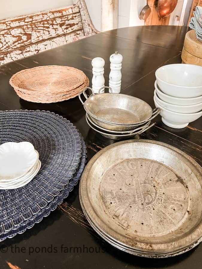Thrift Store Finds include, placemats, old tin pie pans, cordon bleu baking tins, woven plate holders & french bowls.