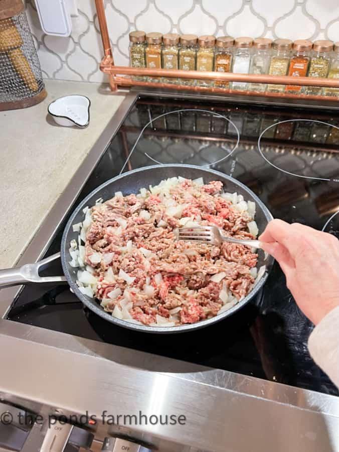 Add ground beef to cooked onions and cook until beef is browned.  Drain liquid before adding to slow cooker.