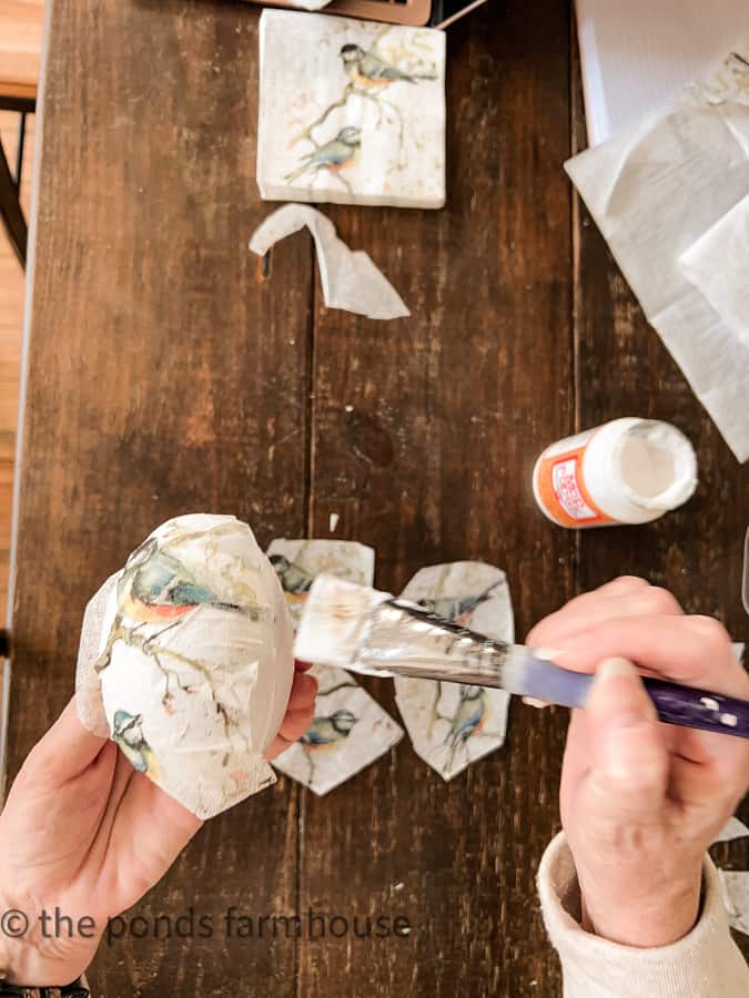 Smooth the napkin on the Easter Egg with a small brush and mod podge to diminish the wrinkles and adhere to egg.