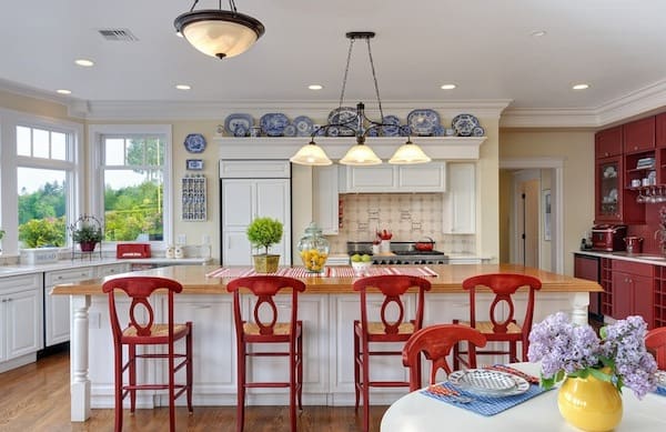 Blue and white dinnerware above cabinets for cottage kitchen decor.