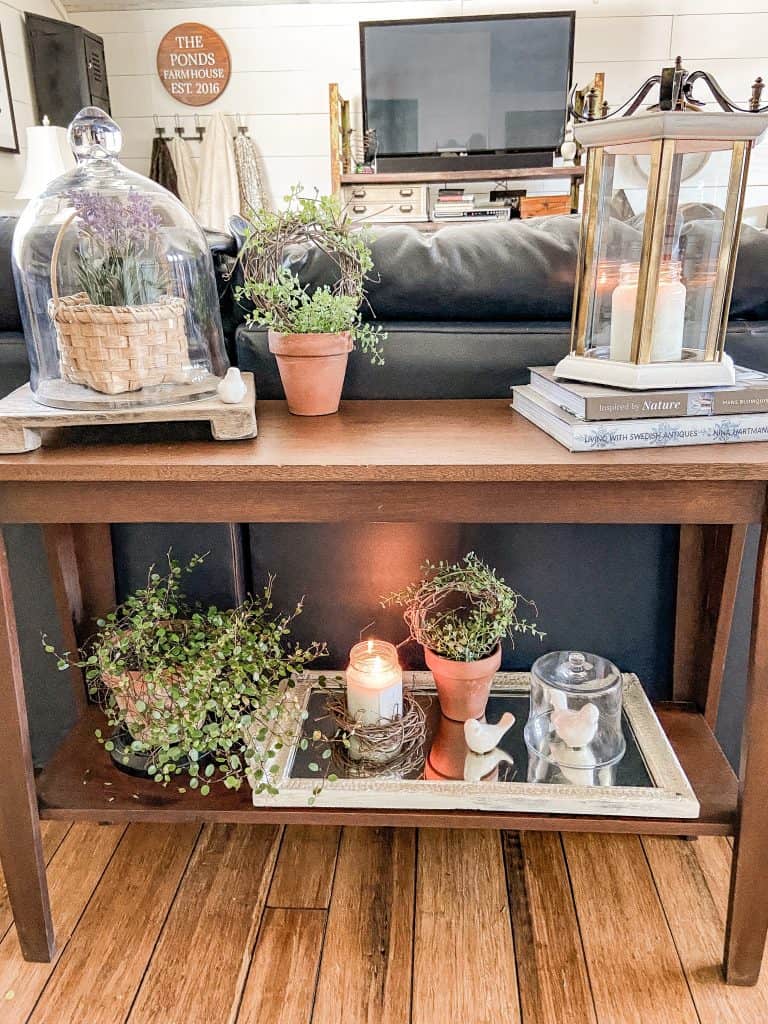 Decorate Sofa Table for Spring with greenery, lanterns, cloches and books.  Console table Decorating ideas