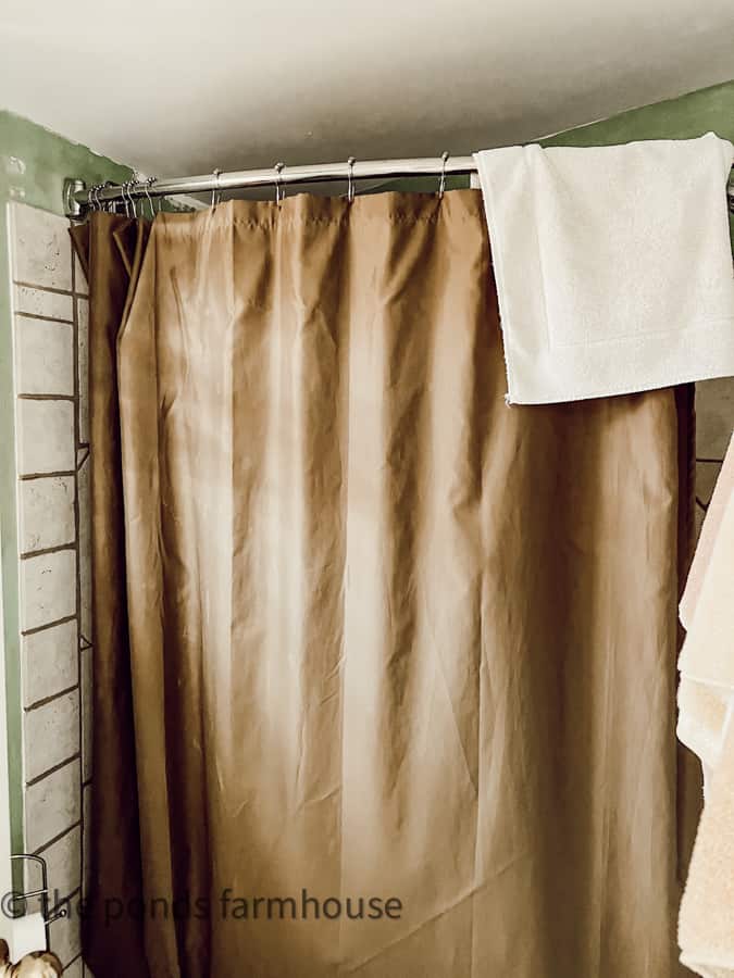 Out of date faux finish wall techiques and brown shower curtain in small bathroom before renovations