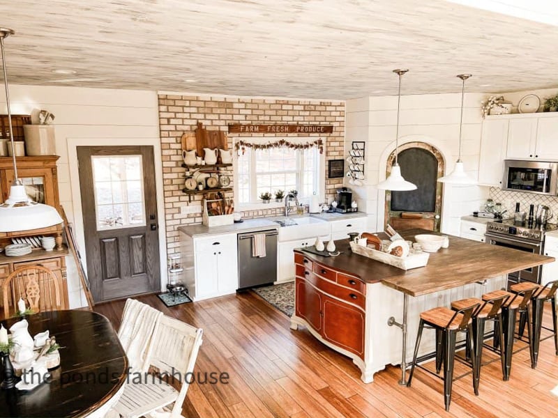 Modern Industrial Farmhouse with open floor plan.  Kitchen with DIY Island and brick walls, shiplap and repurposed pantry door.