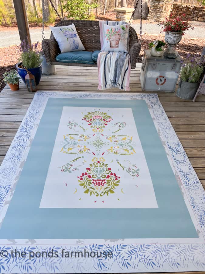 New rug looks great on front porch with blues and pinks next to the porch swing.