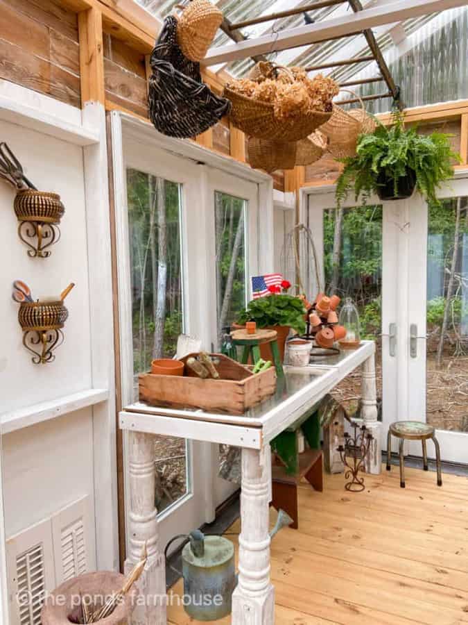 Old porch posts and windows repurposed into a greenhouse garden potting table.  