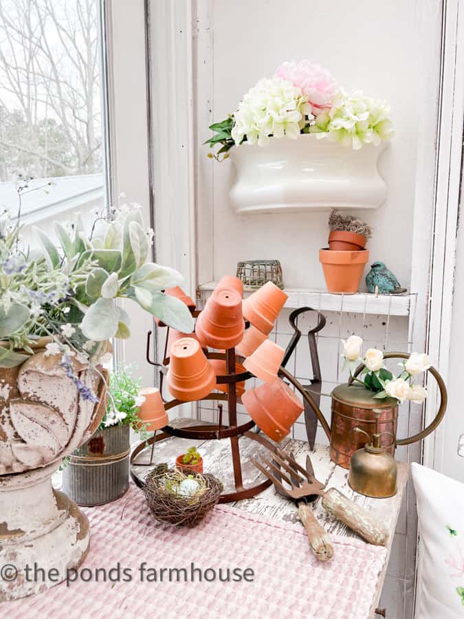 Vintage desk filled with vintage garden tools and birds nest.  Lambs ear fills chippy urn.  