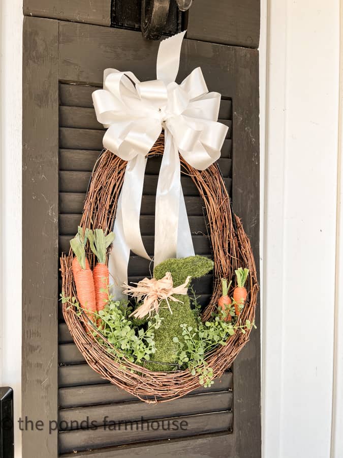 Easter Wreath DIY with white satin box, moss bunny, jute carrots and greenery for Spring decorating.  Cottage style Wreath