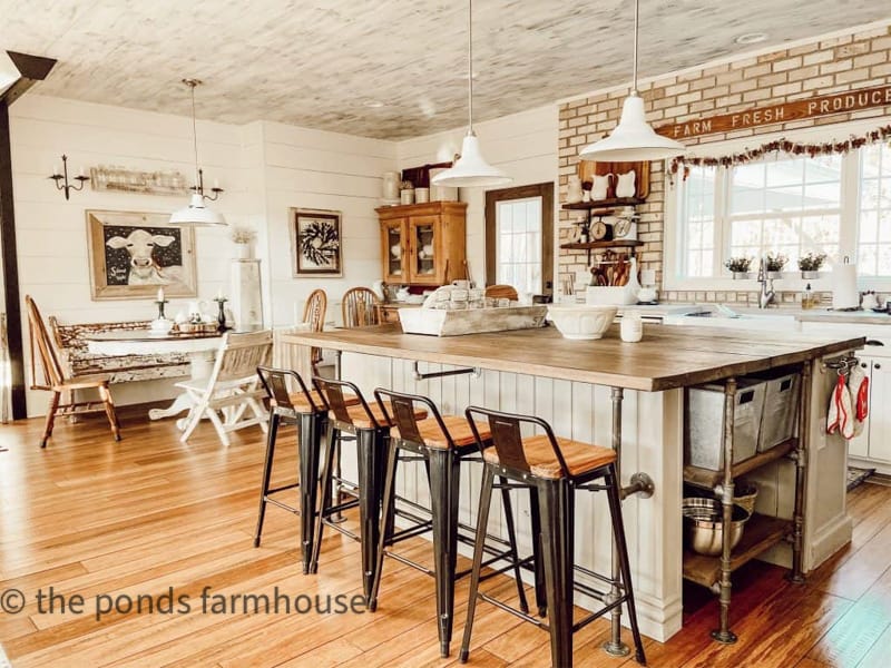 Neutral Industrial style kitchen island in open modern farmhouse  with brick wall and woods and white.