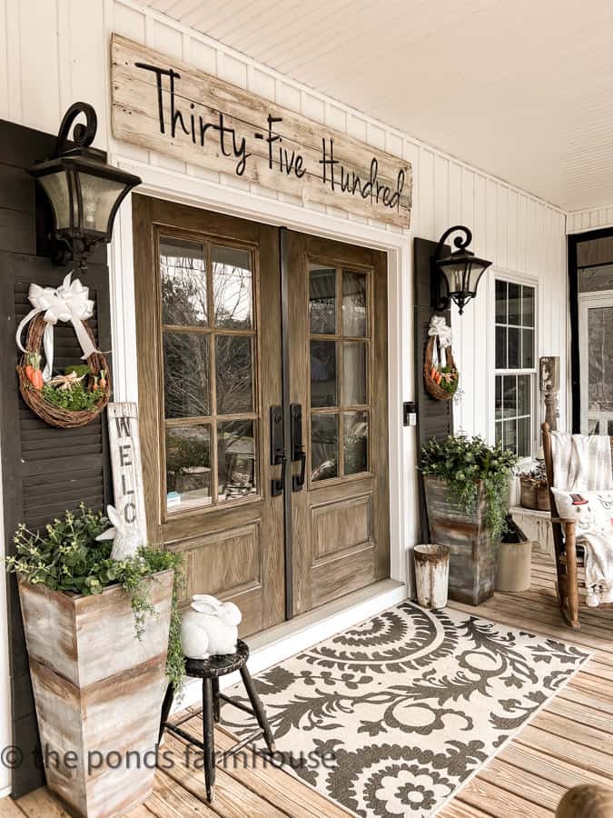 Farmhouse Front Porch with french doors, outdoor rug, planters, DIY wreaths and rockers for Easter Outdoor Decorating.