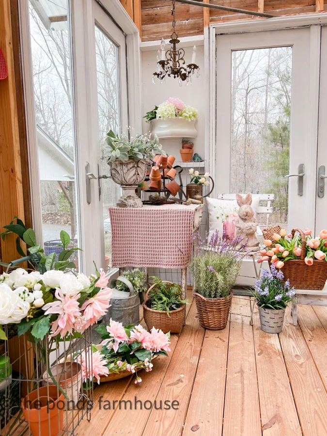 Greenhouse filled with Spring flowers and concrete bunny in corner of She Shed Interior Ideas.