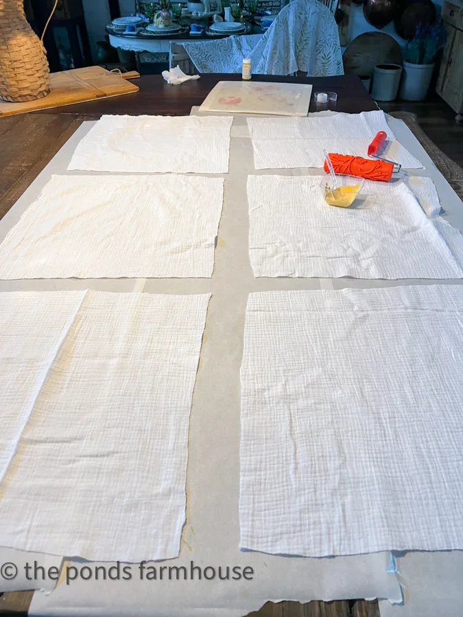 Cut napkins from cotton fabric and lay on protected table top for Custom Napkin tutorial