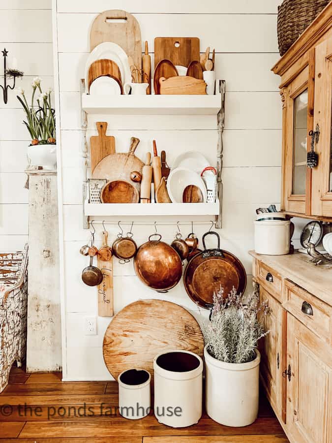 DIY Plate Rack filled with vintage copper, old breadboards, and ironstone platters for Country Chic Decorating.