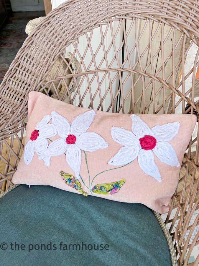 DIY Pillow Cover on wicker chair.  White petals and pink centers made from scrap fabric.  